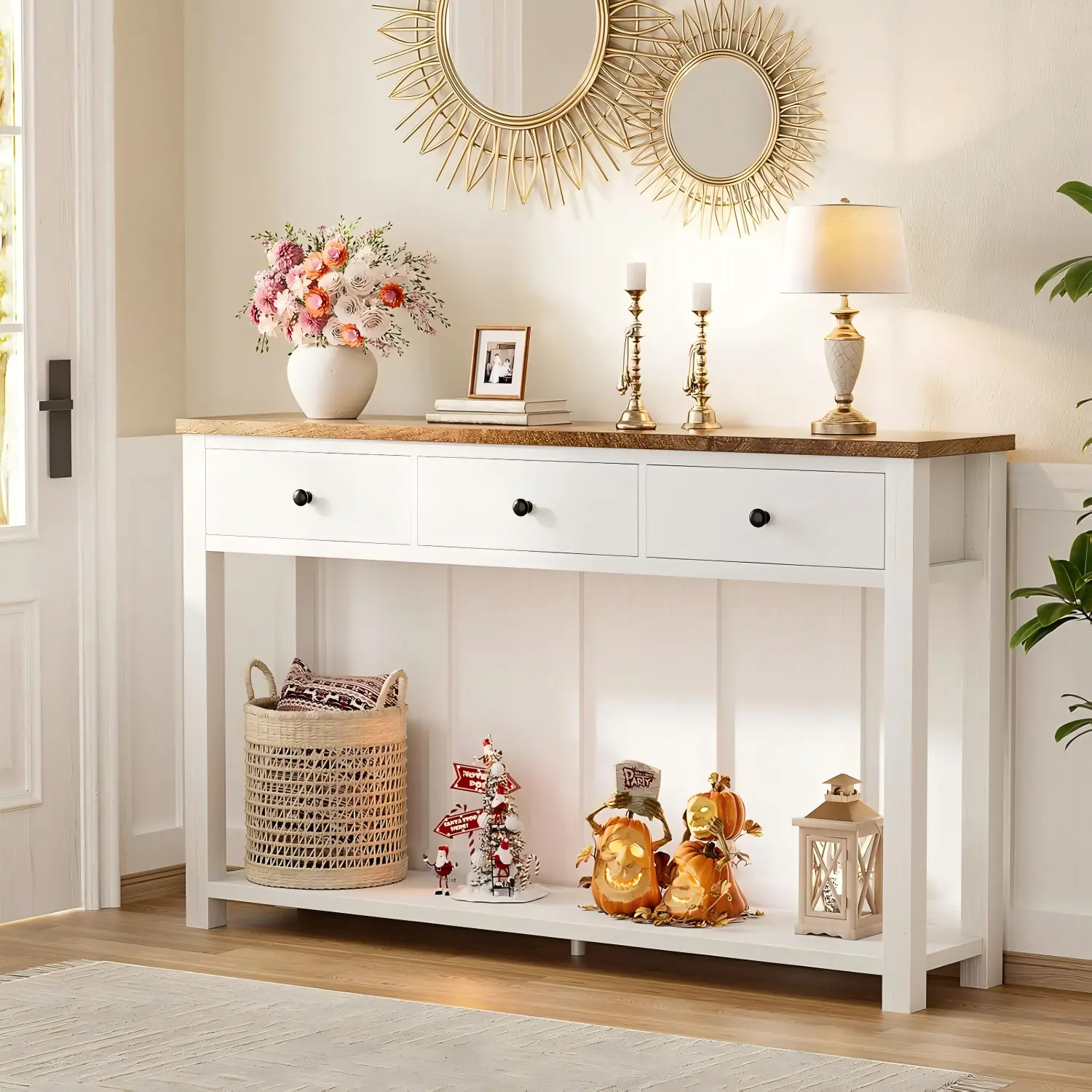 Farmhouse-3-Drawer-Console-Table-Entryway-Lifestyle-Scene White farmhouse console table with 3 drawers and rustic wood top styled with home decor in an entryway lobby